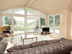 a living room with a couch and a large window at Three-Bedroom Holiday home in Jerup 8 in Jerup