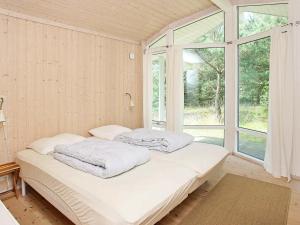 uma cama num quarto com uma grande janela em Three-Bedroom Holiday home in Jerup 8 em Jerup