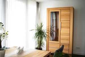 ein Esszimmer mit einem Holzschrank und einem Tisch in der Unterkunft Ferienwohnung Am Schlosspark in Ebersdorf