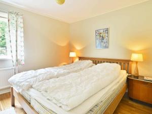 1 cama blanca grande en un dormitorio con 2 lámparas en Two-Bedroom Holiday home in Hallabro 3, en Hallabro