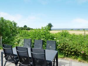 a black table and chairs with a view of a field at 8 person holiday home in Hemmet in Hemmet