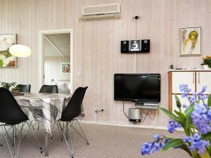 Flovtにある8 person holiday home in Haderslevのテーブル、椅子、テレビが備わる客室です。