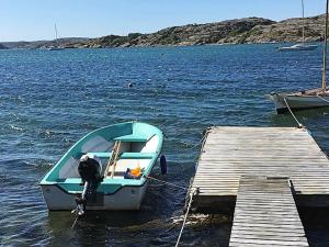 a small boat tied to a dock in the water at 4 person holiday home in HAMBURGSUND in Hamburgsund