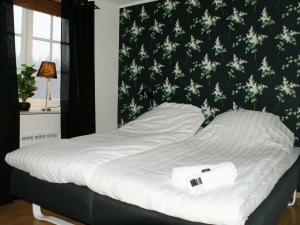 a bed in a bedroom with a black and white wallpaper at 4 person holiday home in H CKSVIK in Håcksvik