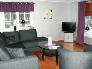 a living room with a couch and a table and a tv at 4 person holiday home in H CKSVIK in Håcksvik