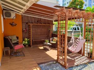 a patio with a hammock and a pergola at Residencial Recanto Paraíso BC - Flat in Balneário Camboriú