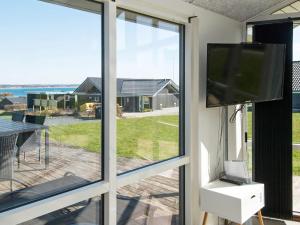 Kelstrupにある12 person holiday home in Haderslevのリビングルーム(テレビ付)、ガラスのスライドドア