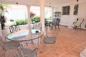 a dining room with a glass table and chairs at B & B Villa Calliandra in Bijilo
