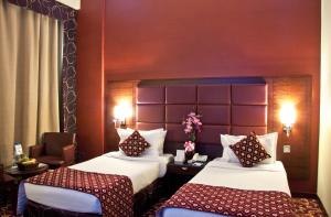 a hotel room with two beds and a chair at Ramee Rose Hotel in Dubai +37 photos