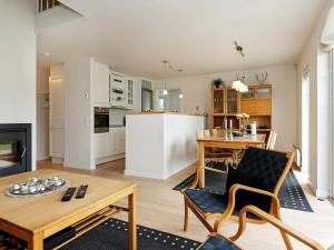 a kitchen and living room with a table and a couch at 6 person holiday home in Vejby in Vejby