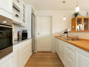 a kitchen with white cabinets and a sink at 6 person holiday home in Vejby in Vejby