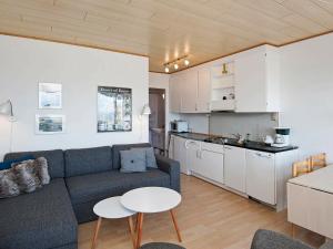 a living room with a couch and a table and a kitchen at Holiday Home Lyngvejen VI in Rømø Kirkeby