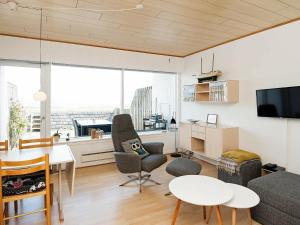 een woonkamer met een tafel en stoelen en een televisie bij Holiday Home Lyngvejen VI in Rømø Kirkeby