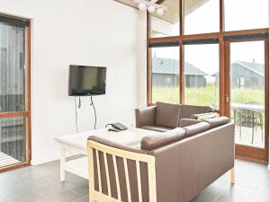 a living room with a couch and a tv at 8 person holiday home in Ulfborg in Thorsminde