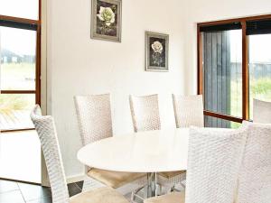 Thorsmindeにある8 person holiday home in Ulfborgの白いダイニングルーム(白いテーブルと椅子付)