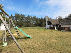 an outdoor playground with a slide and a building at 6 person holiday home in L s in Læsø