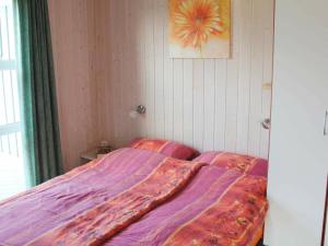 a bedroom with a bed with a colorful blanket at 6 person holiday home in Otterndorf in Otterndorf