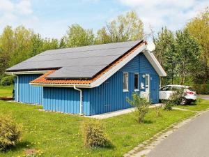 ein blaues Haus mit Sonnenkollektoren darüber in der Unterkunft 6 person holiday home in Otterndorf in Otterndorf