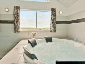 bañera con 2 sillas y ventana en 22 person holiday home in Harbo re, en Harboør