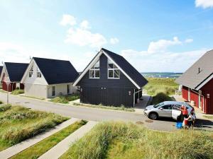 a black house and a car parked in front of a house at 6 person holiday home in Wendtorf in Wendtorf