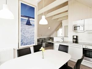 6 person holiday home in Wendtorf في Wendtorf: مطبخ وغرفة طعام مع طاولة وكراسي بيضاء