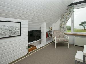 ein Wohnzimmer mit einem Stuhl und einem großen Fenster in der Unterkunft 6 person holiday home in Hemmet in Hemmet
