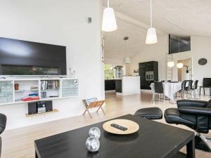 sala de estar con mesa negra y sillas en Three-Bedroom Holiday home in Løgstør 6, en Trend