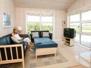 een vrouw op een bank in een woonkamer bij 5 person holiday home in L kken in Løkken