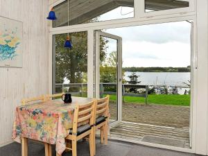 comedor con mesa y vistas al agua en 4 person holiday home in Haderslev en Diernæs