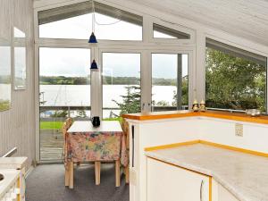 cocina con mesa, sillas y ventanas en 4 person holiday home in Haderslev en Diernæs