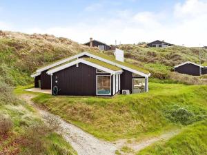 una casa negra en la cima de una colina en 8 person holiday home in Saltum, en Saltum