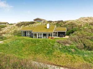 una casa sentada en la cima de una colina cubierta de hierba en 8 person holiday home in Saltum, en Saltum