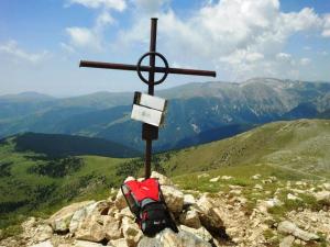 a cross on top of a mountain with a backpack at Apartamentos Rurales Les Barnedes in Molló