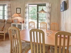 uma sala de jantar com uma mesa de madeira e cadeiras em 6 person holiday home in Nex em Snogebæk