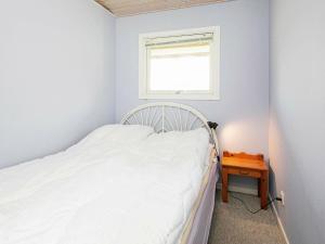 a small bedroom with a bed and a window at 8 person holiday home in Stege in Stege