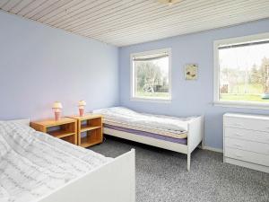a bedroom with two beds and two windows at 8 person holiday home in Stege in Stege