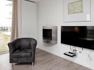 a living room with a chair and a flat screen tv at One-Bedroom Holiday home in Wendtorf 11 in Wendtorf