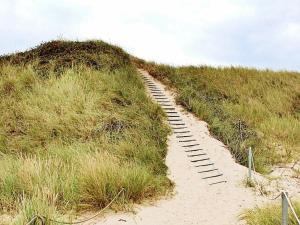 a wooden path in the sand on a beach at 5 person holiday home in Ulfborg in Fjand Gårde