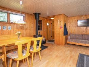 een eetkamer met een tafel en een houtkachel bij 6 person holiday home in S by in Sæby