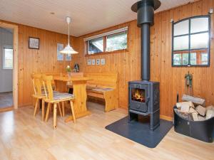 una sala de estar con estufa de leña en una casa en 6 person holiday home in S by en Sæby