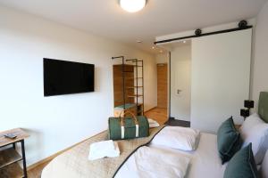 ein Wohnzimmer mit einem Sofa und einem Flachbild-TV in der Unterkunft Naturhotel Wittelsbach in Aichach