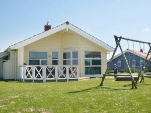 a boy on a swing in front of a house at 6 person holiday home in Otterndorf in Otterndorf