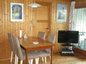 a dining room table with chairs and a television at 4 person holiday home in Skibby in Skibby