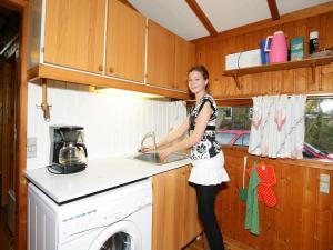 una donna in piedi in una cucina con lavandino di 4 person holiday home in Skibby a Skibby