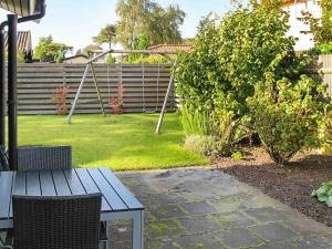 a garden with a table and chairs and a fence at 6 person holiday home in Str by in Strøby