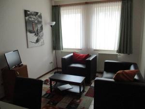 a living room with two chairs and a television at Fishermans in Borkum