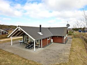 a small house with a roof with a patio at 8 person holiday home in Juelsminde in Sønderby