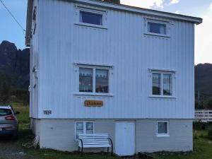 una casa blanca con un banco delante en 6 person holiday home in Senjahopen, en Mefjordvær