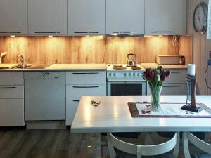 une cuisine avec une table et un vase de fleurs. dans l'établissement 6 person holiday home in Senjahopen, à Mefjordvær