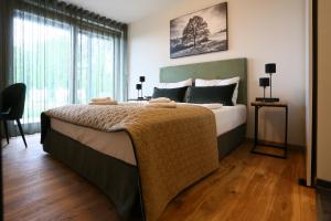 a bedroom with a large bed and a large window at Naturhotel Wittelsbach in Aichach